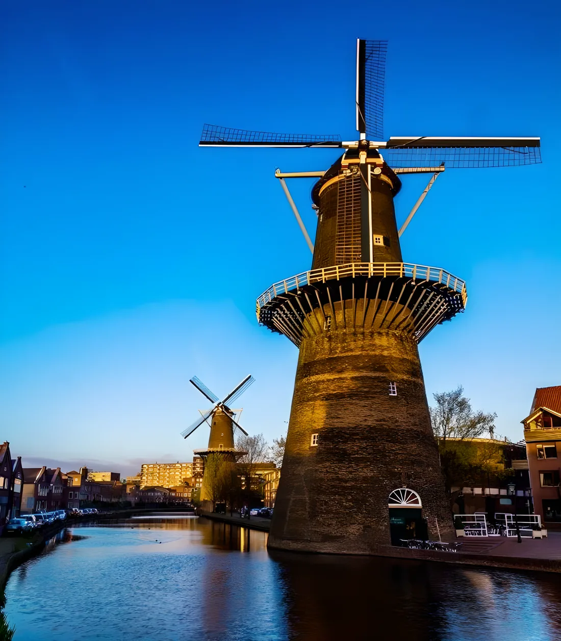 Molen De Noord in het avondlicht aan de Noordvest in Schiedam, met daarachter een tweede molen langs de gracht