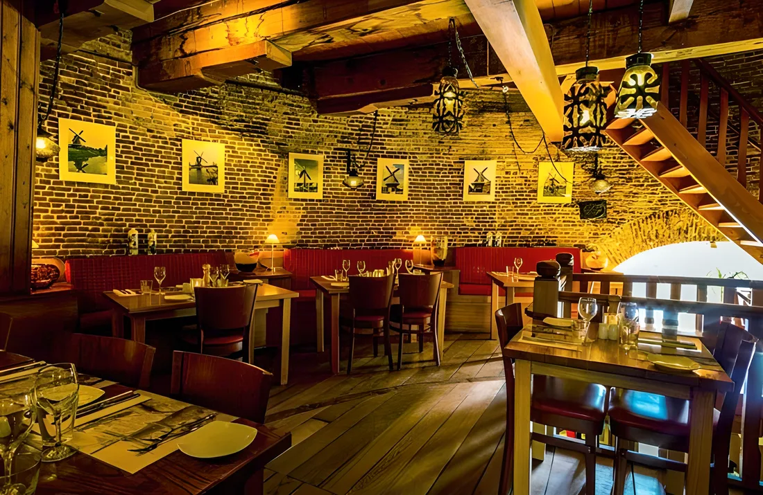 Het restaurant met gedekte tafels tegen het oude metselwerk van de molen