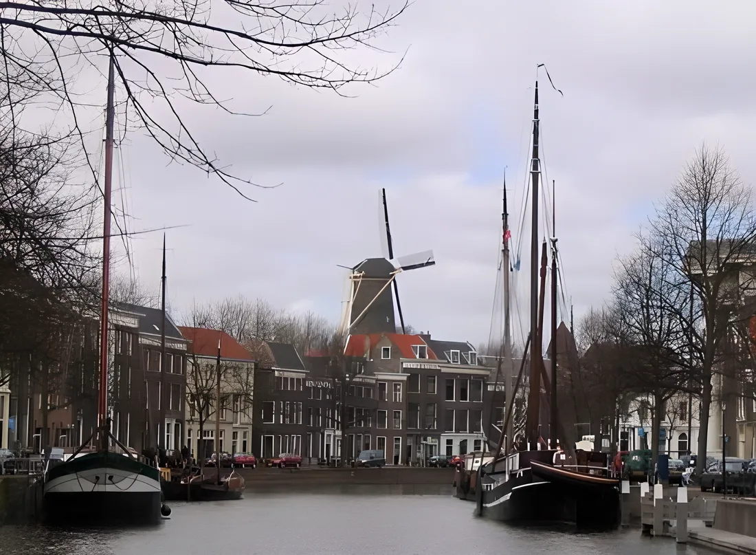 Historische schepen in de Schiedamse gracht met een molen op de achtergrond