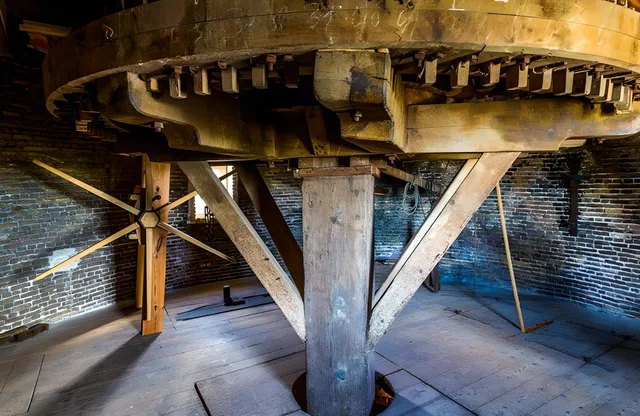 Het houten wielwerk van de molen op een van de bovenverdiepingen